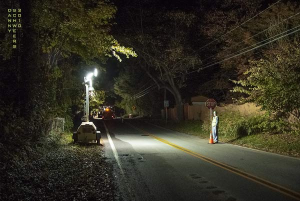 Flagman with STOP sign on lonely road at night, Arden, Delaware