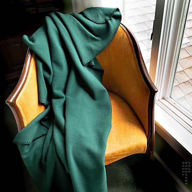 Green blanket on an orange chair by Danny N. Schweers