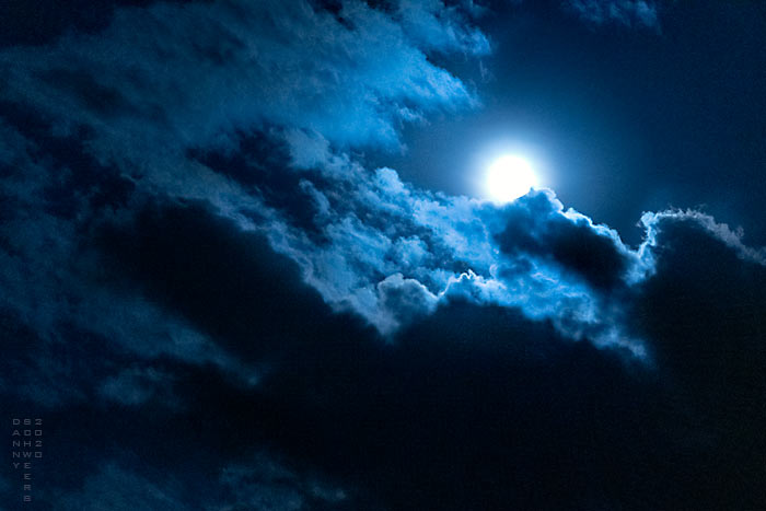 Photo of full moon and clouds by Danny N. Schweers