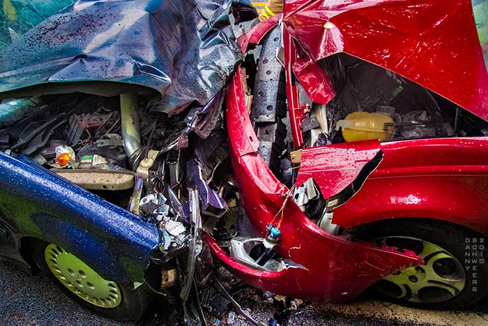 Photo of blue and red sedans after a head-on collision by Danny N. Schweers