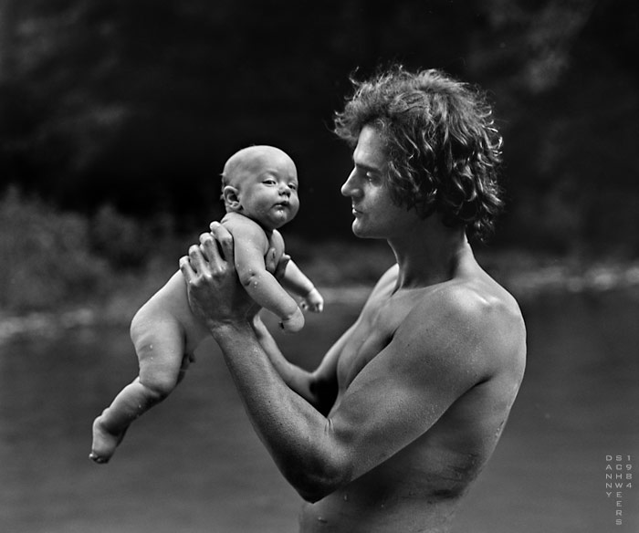 Man holding child above the river in Wimberley, Texas, photo by Danny N. Schweers, 1984
